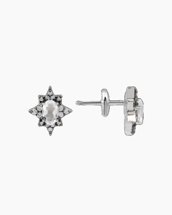 A pair of white gold earrings with a star-shaped design featuring white topaz stones.