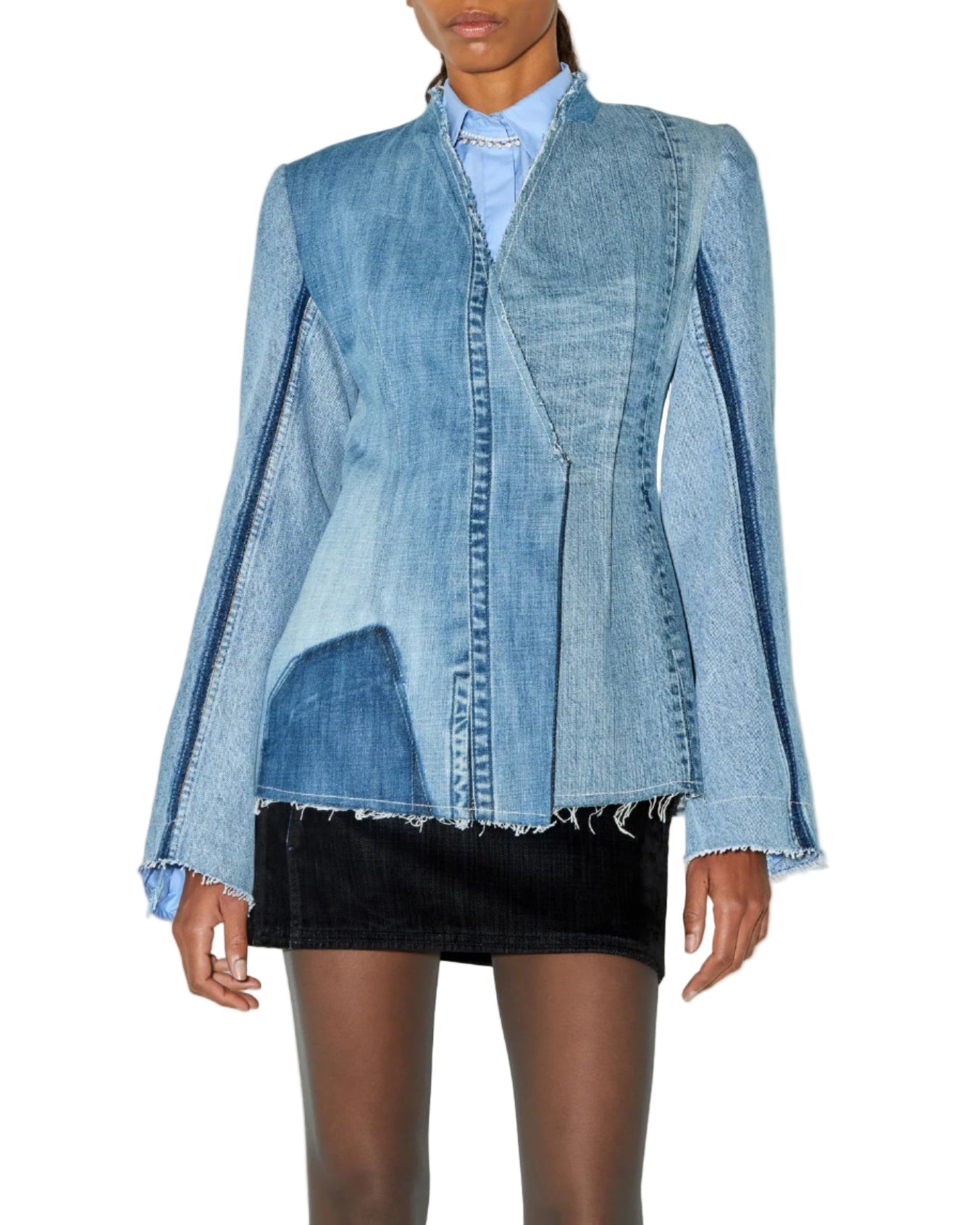 Person wearing a denim jacket over a black skirt on a white background